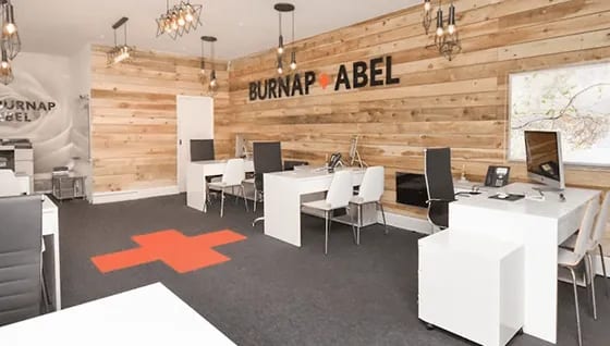 Open office workspace in Dover with Burnap Abel branding on the wood wall
